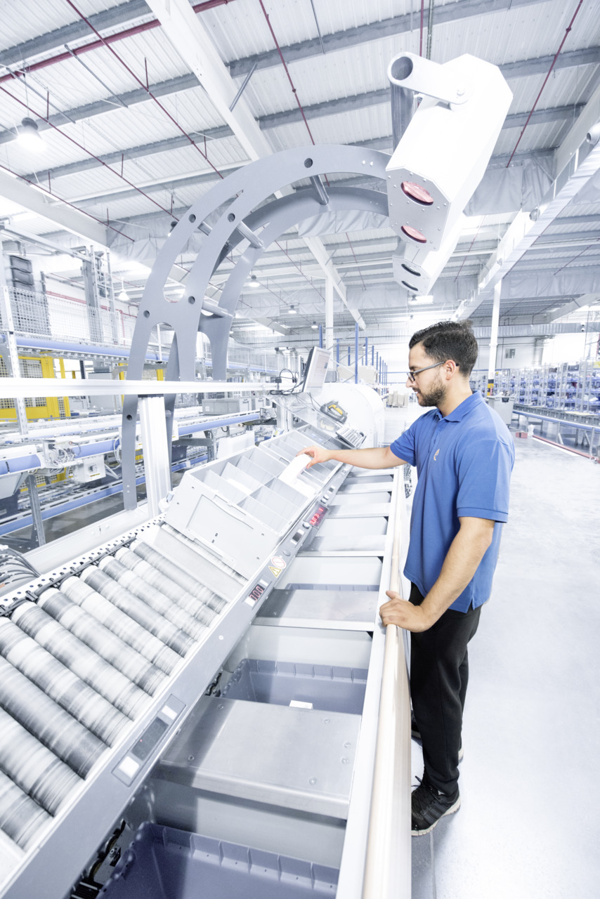 Man pickt orders in combinatie met geautomatiseerde orderpicksystemen in een magazijn