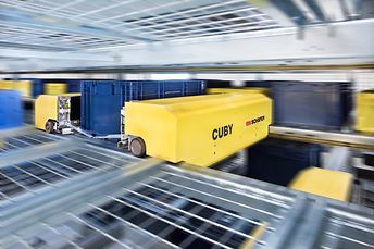 Shuttle system cuby with on rack for storing containers and cartons