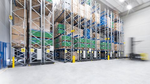 Hoge schappen gevuld met pallets en dozen in een magazijn