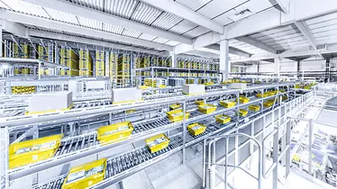 producten met gele kleur worden in een groot magazijn opgeslagen en vervoerd met transportbanden