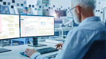 Man analyseert logistieke software WAMAS via een computer