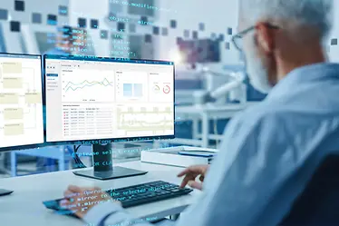 Man analyseert logistieke software WAMAS via een computer