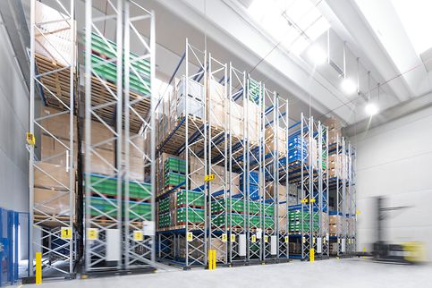 Hoge schappen gevuld met pallets en dozen in een magazijn